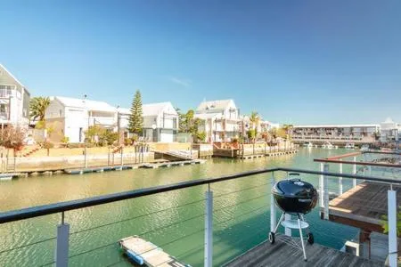 Waterfront view of Knysna lagoon with moored boats and residential buildings