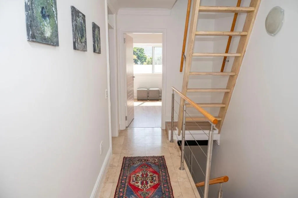 Modern hallway with wooden staircase and contemporary metal railings
