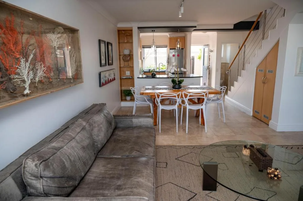 Open-plan lounge with gray sofa, dining area, and kitchen visible beyond
