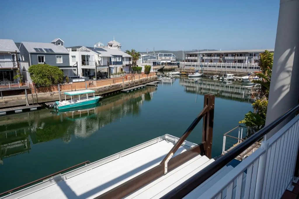 Scenic waterfront canal view with moored boats and coastal architecture