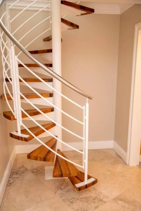 Modern spiral staircase with white railings and wooden steps in contemporary home