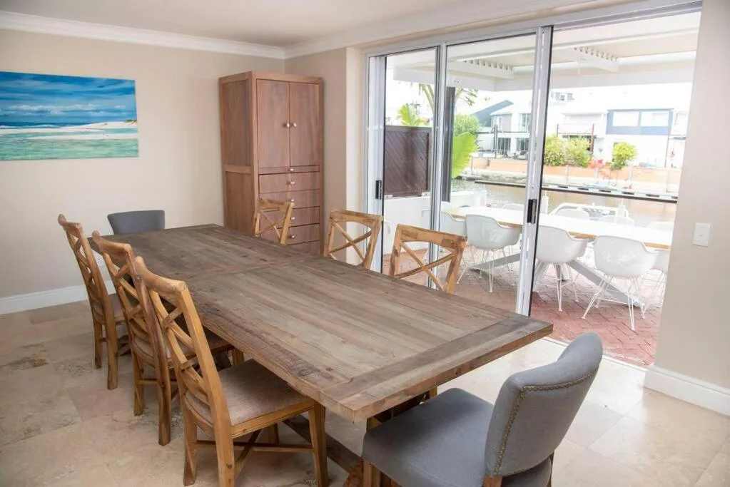 Spacious dining area with wooden table and chairs overlooking outdoor deck