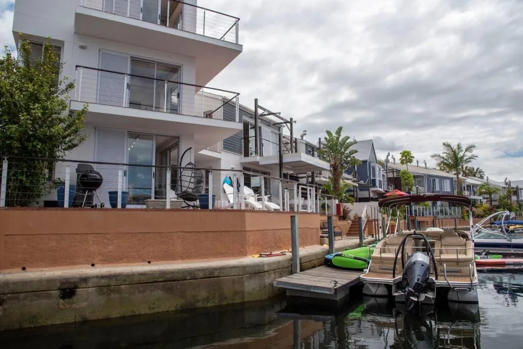 Modern waterfront property with multiple balconies and boat dock access