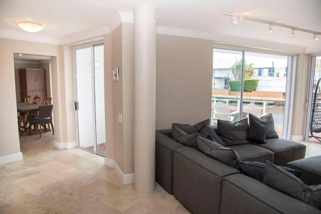 Spacious lounge with dark modular sofa and glass doors overlooking deck