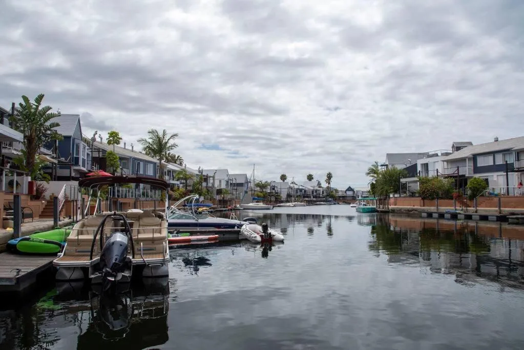 Waterfront lagoon view with moored boats and residential buildings