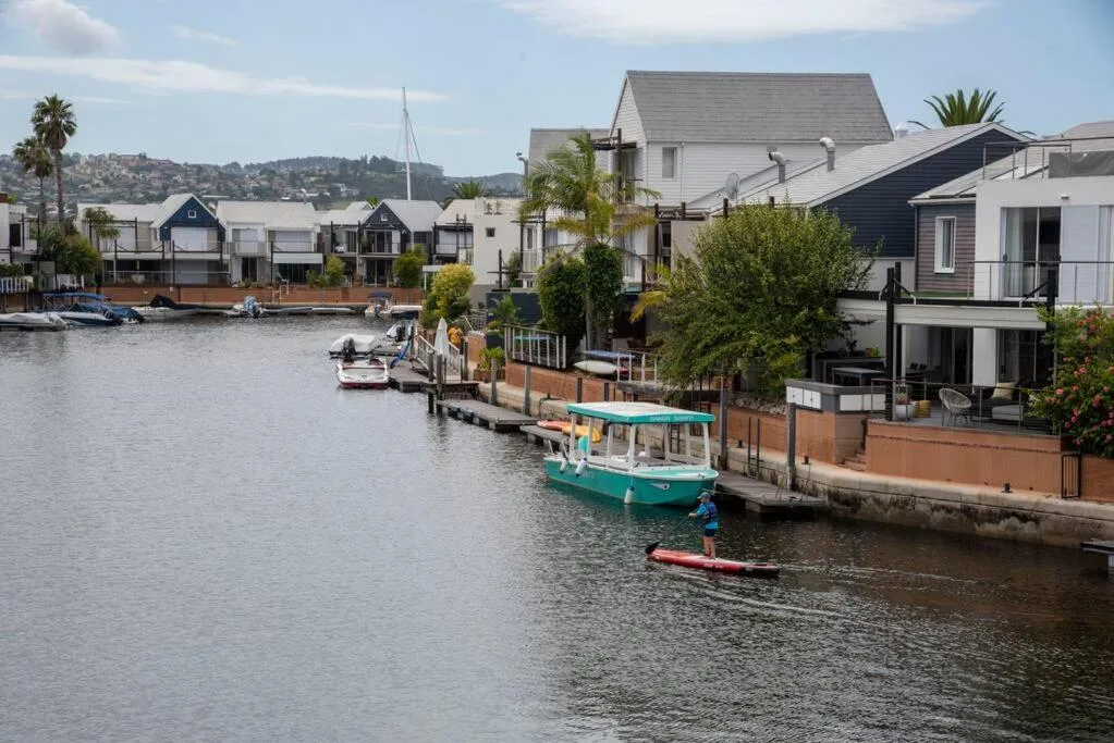 Waterfront property with lagoon views, boats, and palm trees
