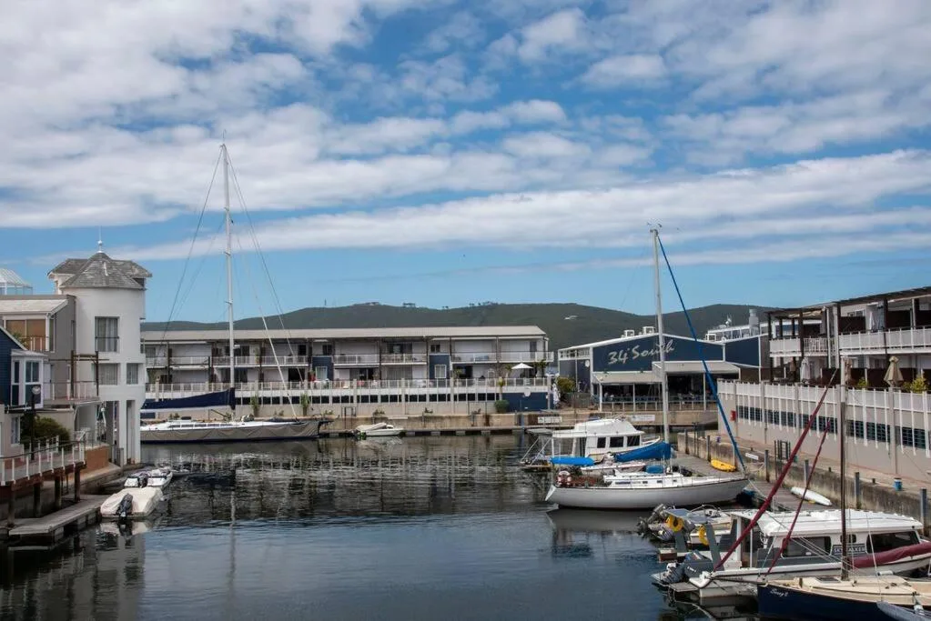 Waterfront harbor with moored sailboats and hills, Knysna