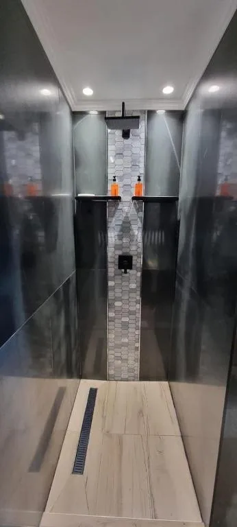 Modern bathroom with walk-in shower and tiled accent wall
