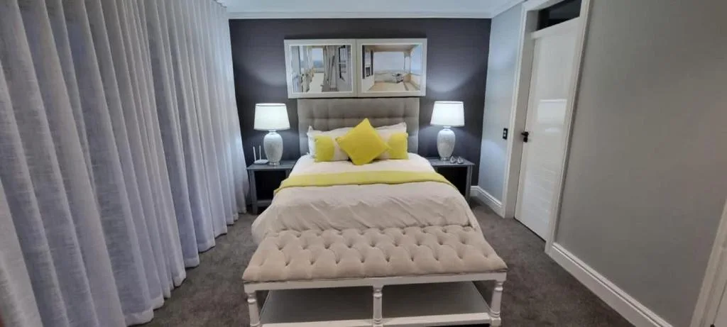 Modern bedroom with upholstered headboard and yellow accent pillows