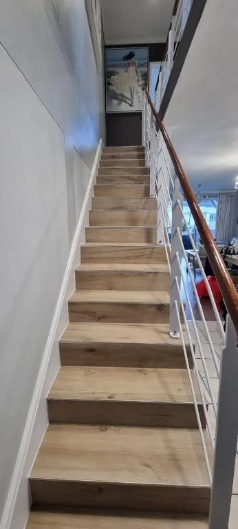 Wooden staircase with white railings leading upstairs indoors