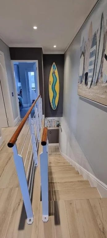 Hallway with surfboards and coastal artwork decorations