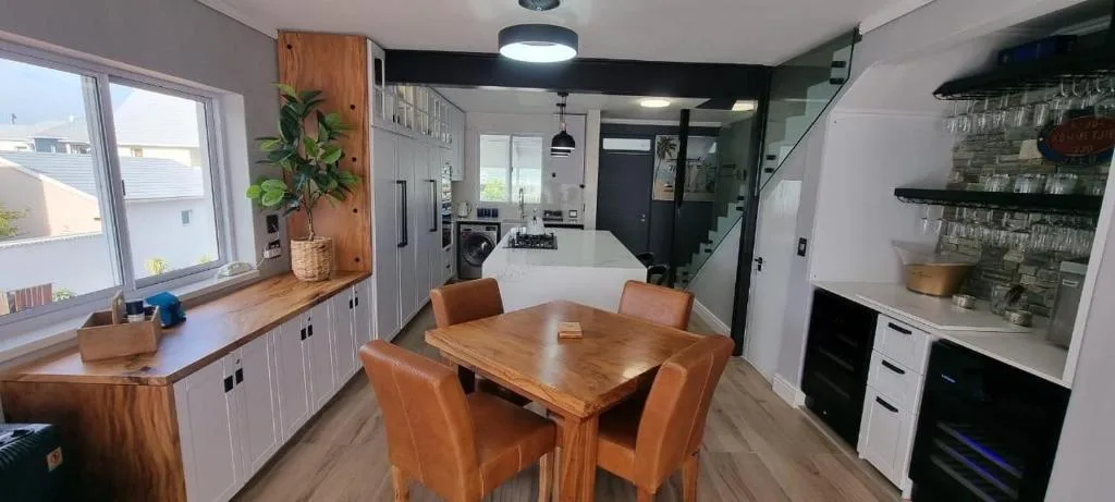 Open-plan dining area with wooden table and orange leather chairs