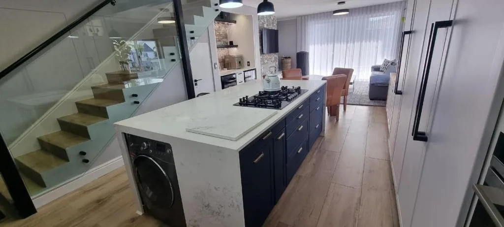 Modern open-plan kitchen with island, gas cooktop, and navy cabinetry