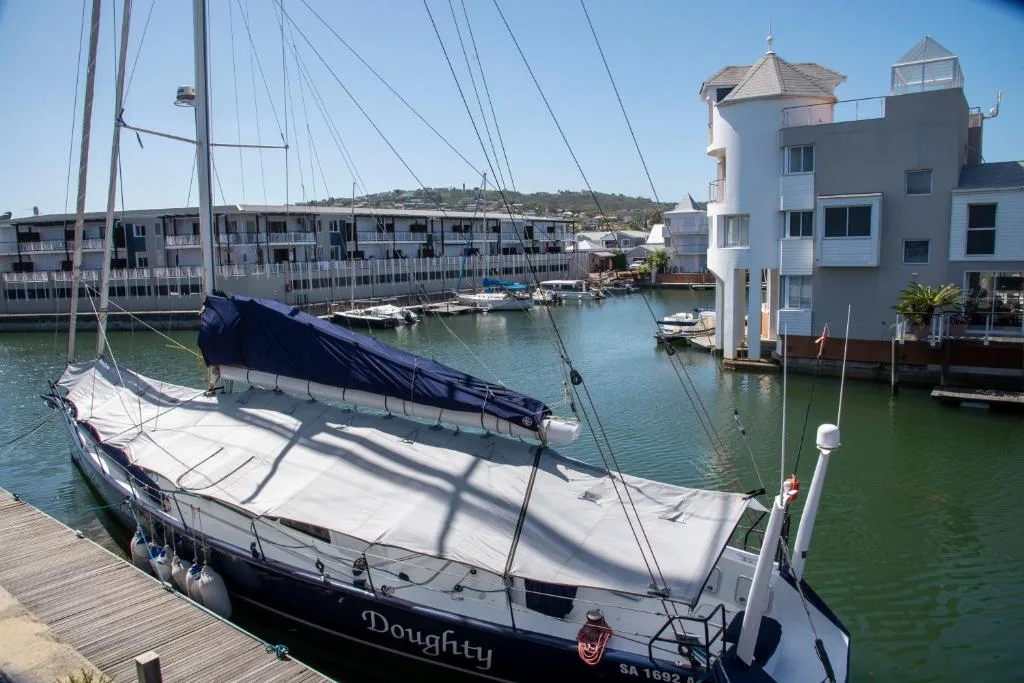 Scenic waterfront view of sailboats moored in Knysna canal with hillside homes