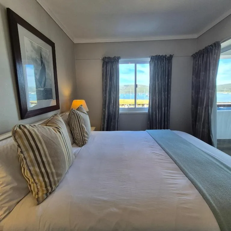 Bright bedroom with ocean view through French doors and water vista