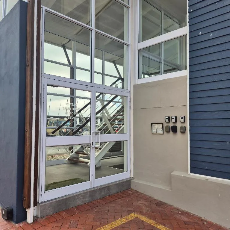Modern apartment entrance with large glass doors and navy siding