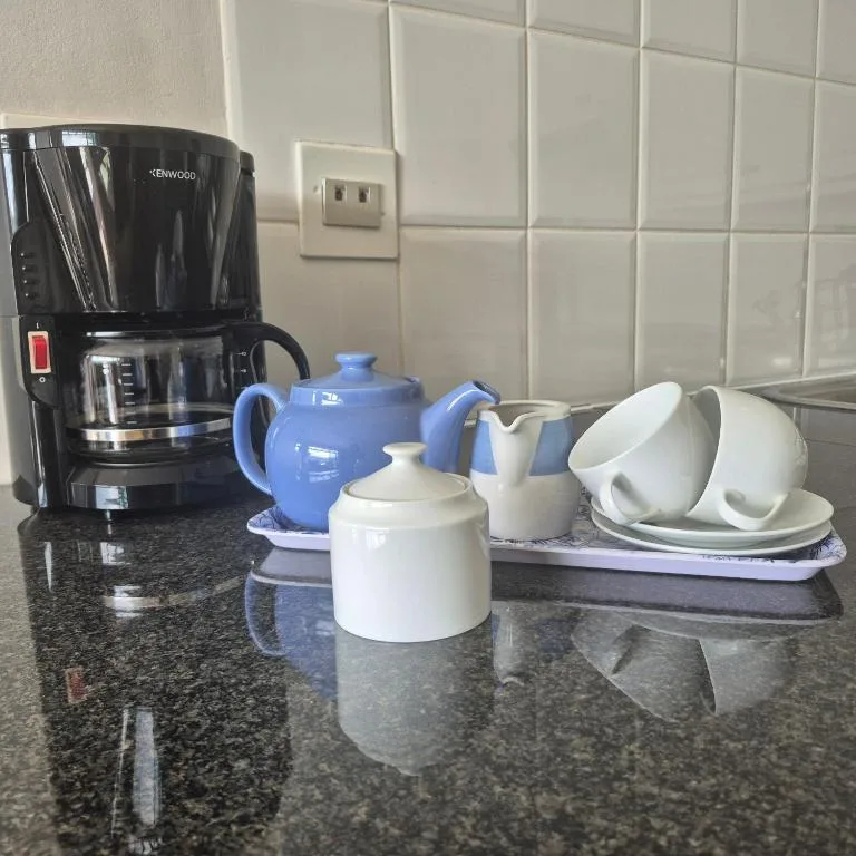 Kitchen counter with coffee maker, teapot, and white porcelain tableware