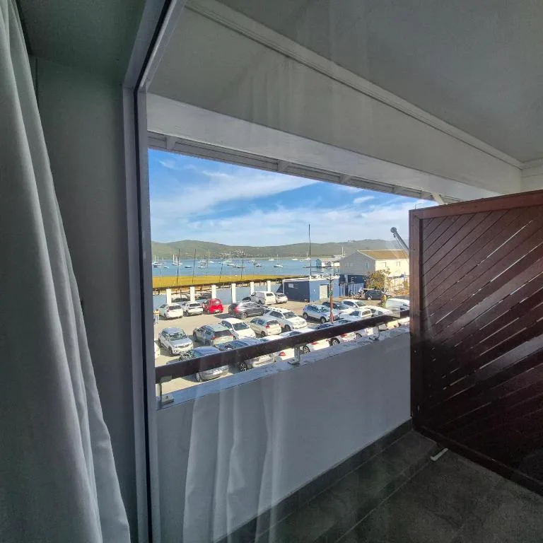 Scenic harbor view with boats and mountains from indoor window