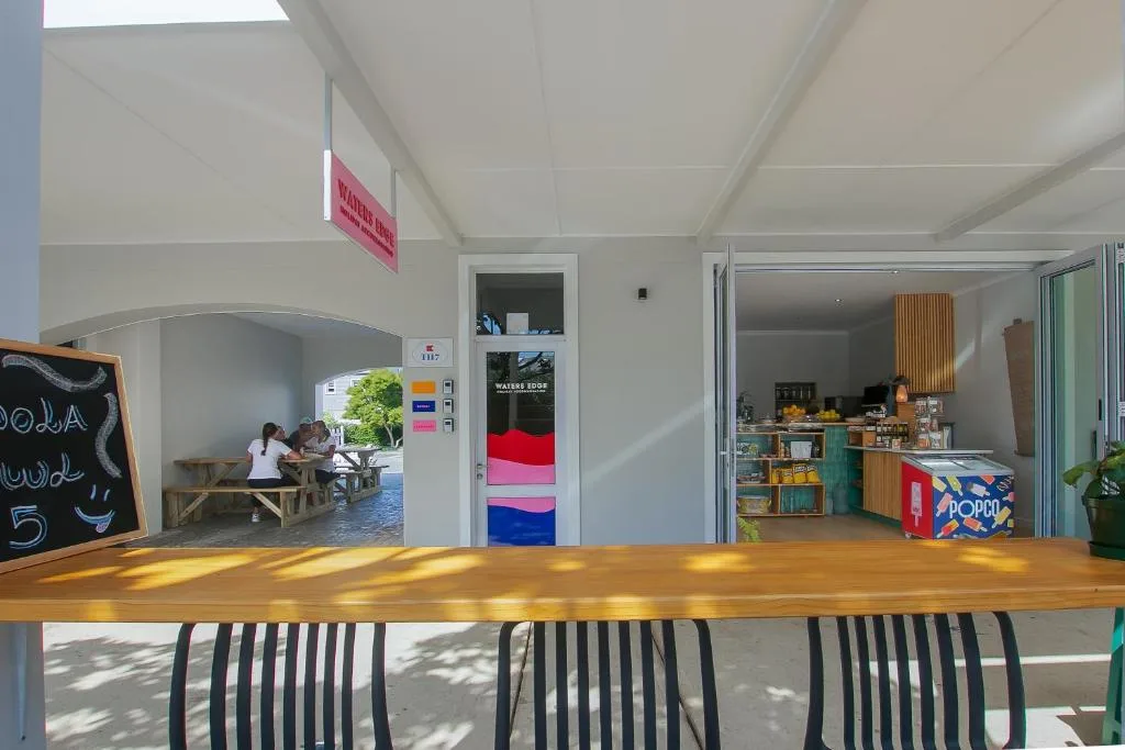 Open-plan interior with kitchen, dining counter, and bright communal living space