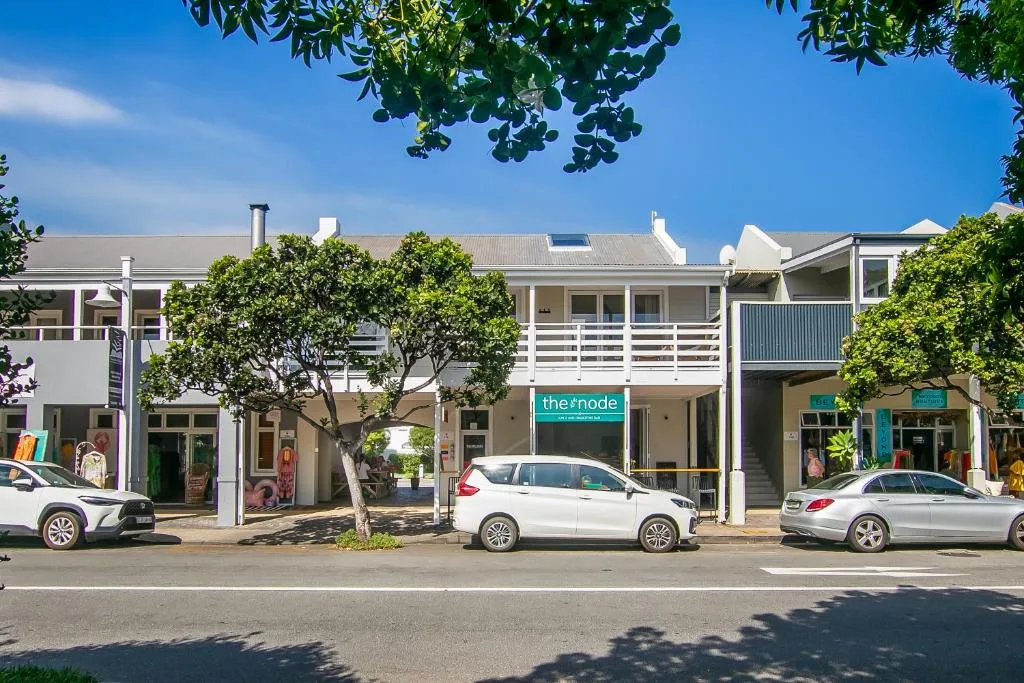 White Cape Dutch style building facade with ground floor shops and upper level apartments