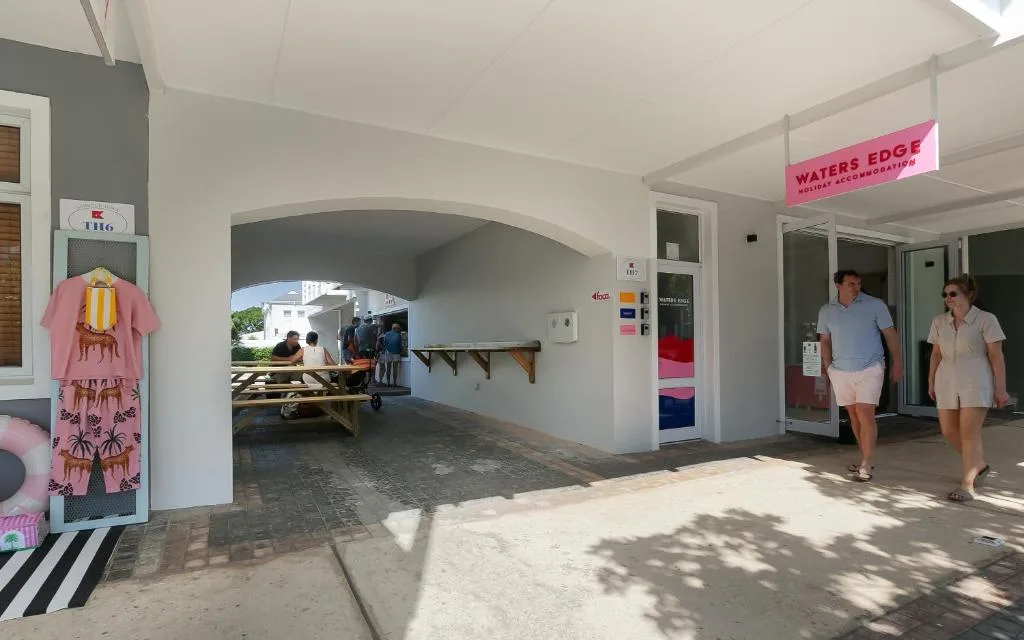 Covered entrance to Waters Edge apartment with arched breezeway and signage