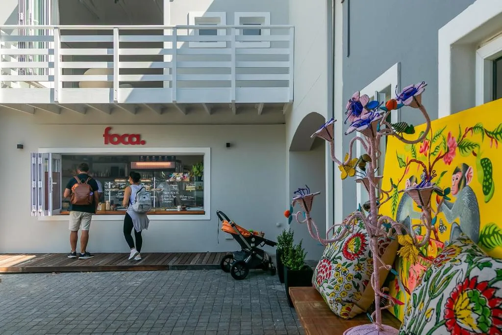 Modern apartment building entrance with café and vibrant garden art installation