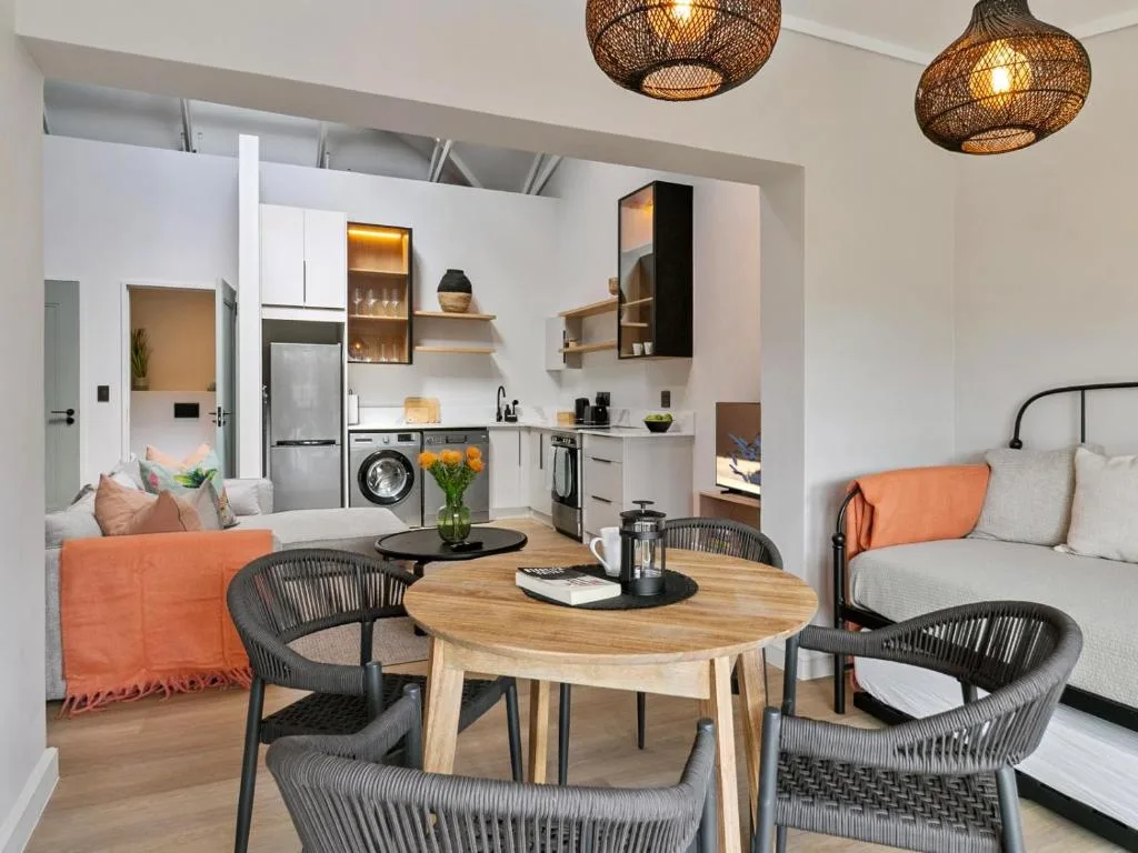 Open-plan lounge with dining table, woven pendant lights, modern furnishings