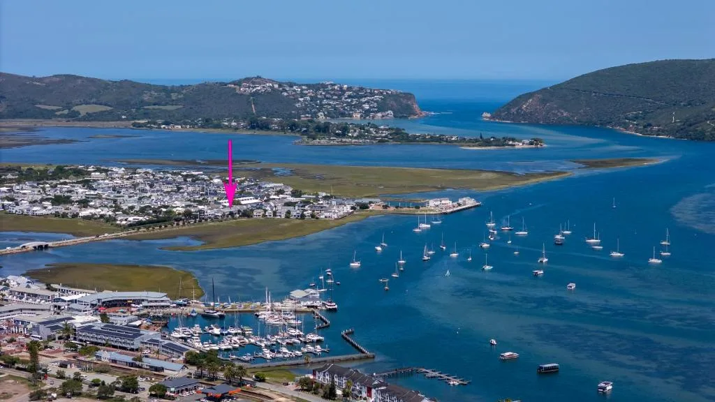 Aerial view of Knysna Heads with turquoise lagoon, moored sailboats, and surrounding mountains