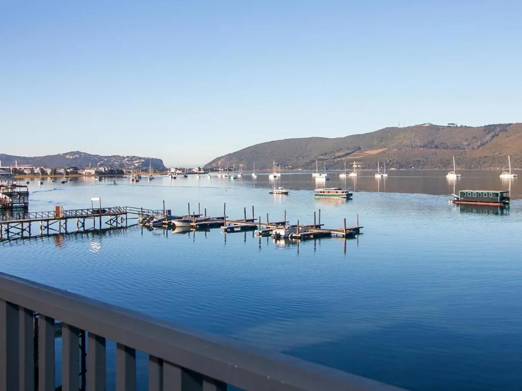 Serene lagoon view with moored boats and surrounding mountains
