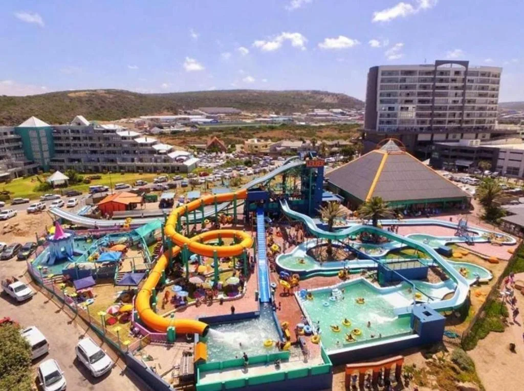 Aerial view of colorful water park with slides and pools, surrounding accommodations