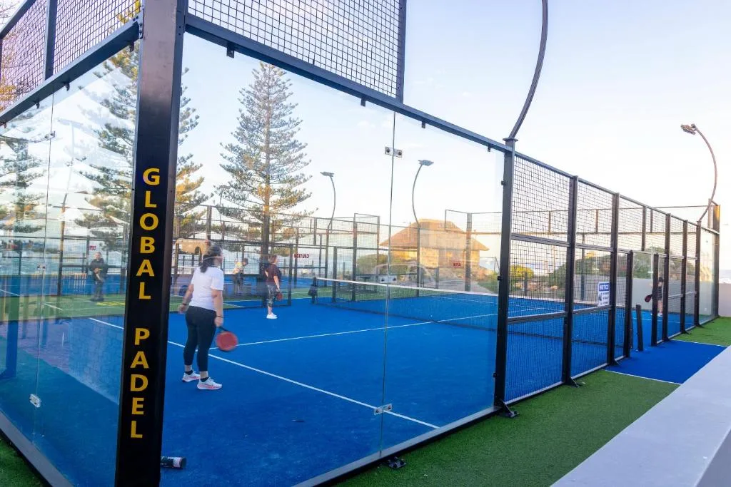 Padel court facility with blue playing surface and protective netting