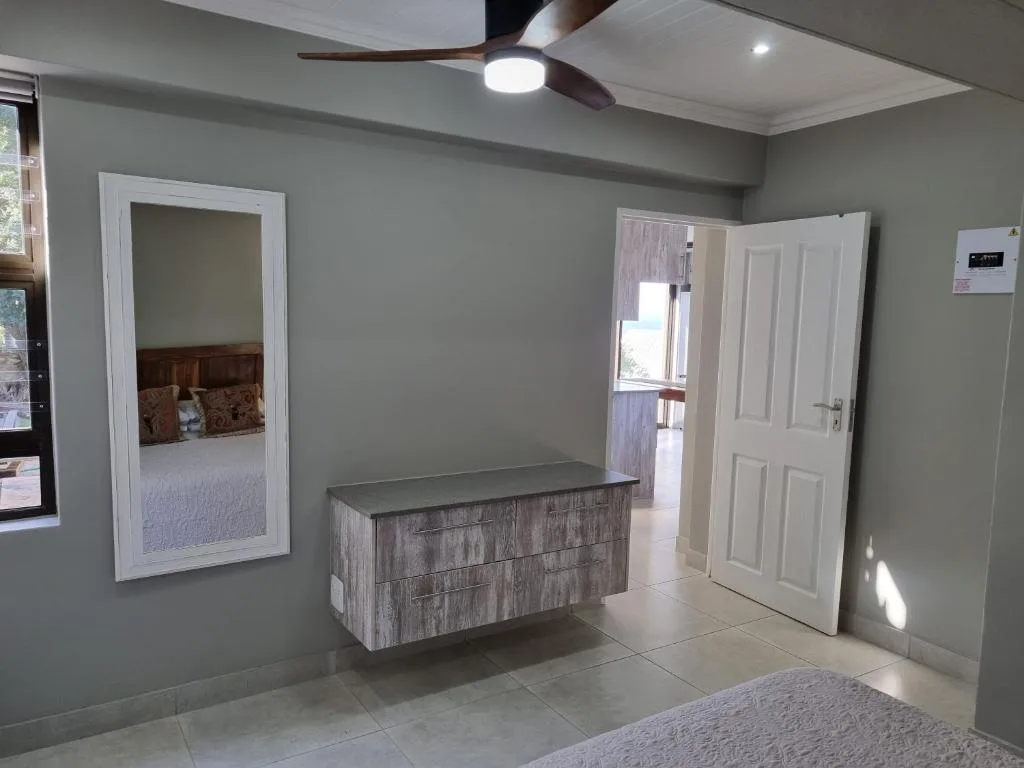 Modern lounge area with ceiling fan, neutral walls, and open floor plan