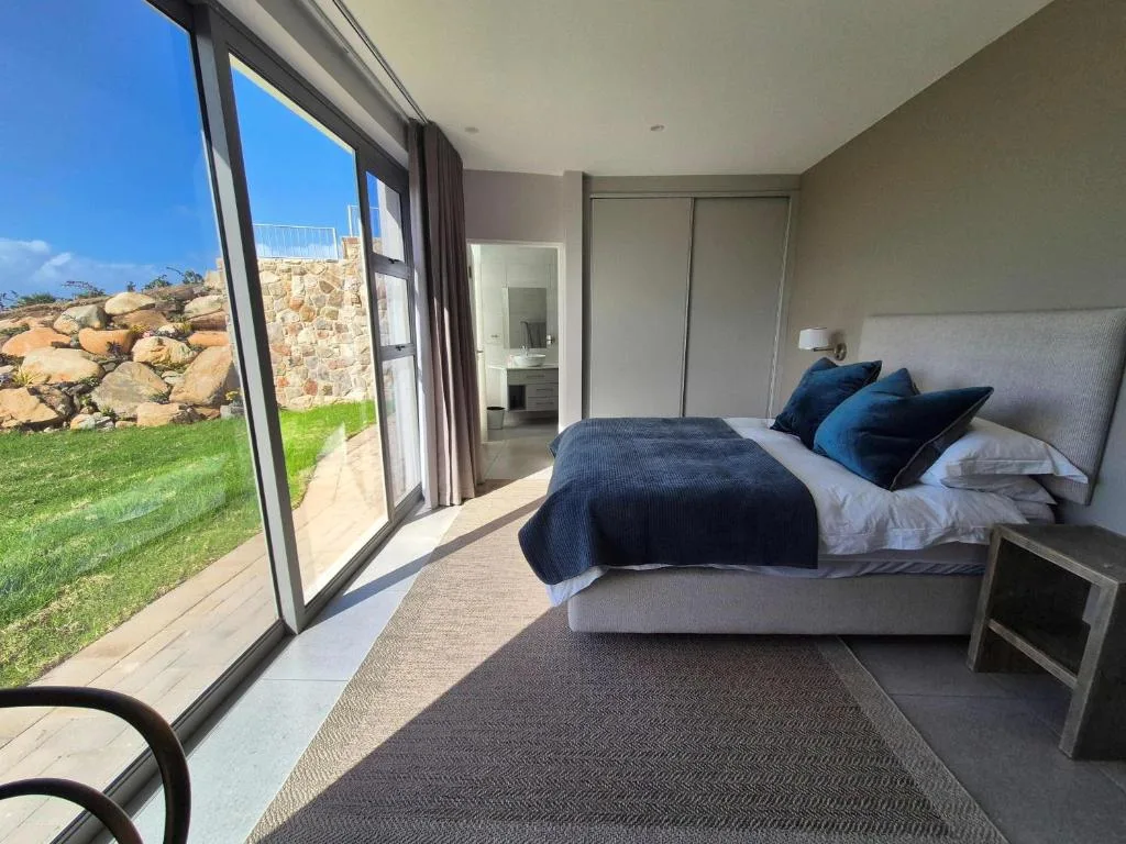 Modern bedroom with queen bed, garden views through large sliding doors