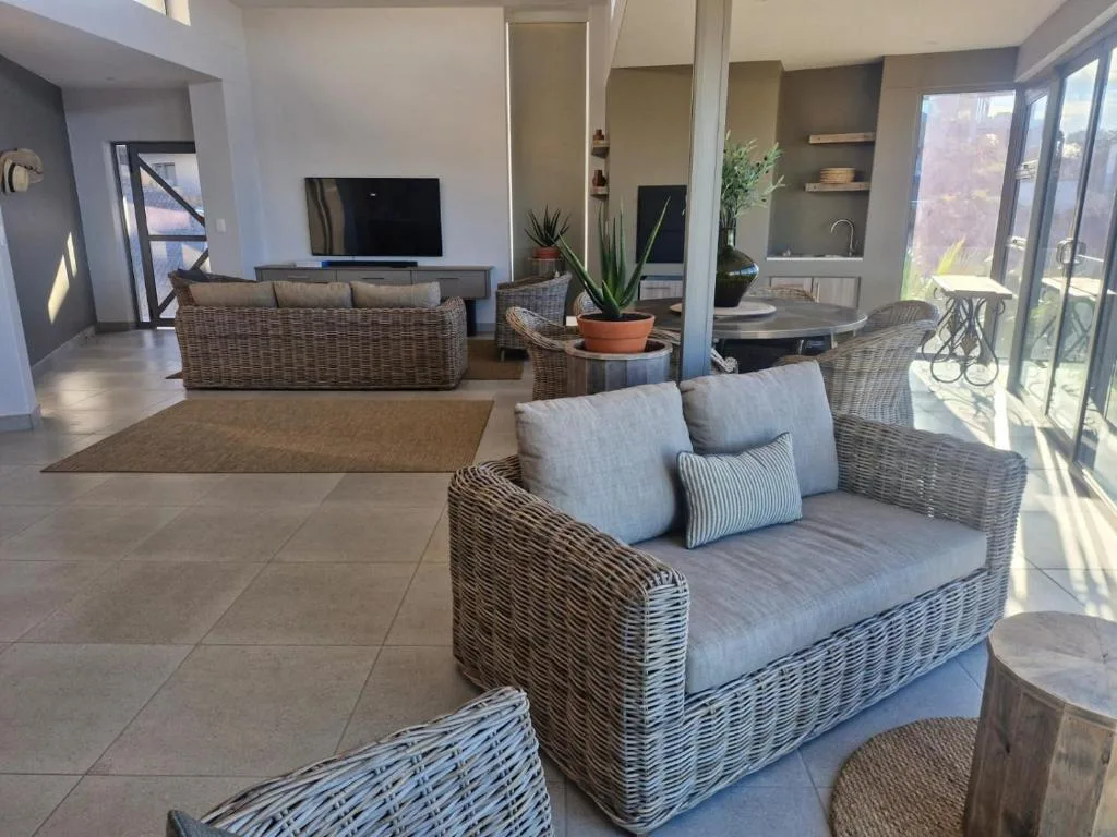 Spacious open-plan lounge with wicker seating and television entertainment area