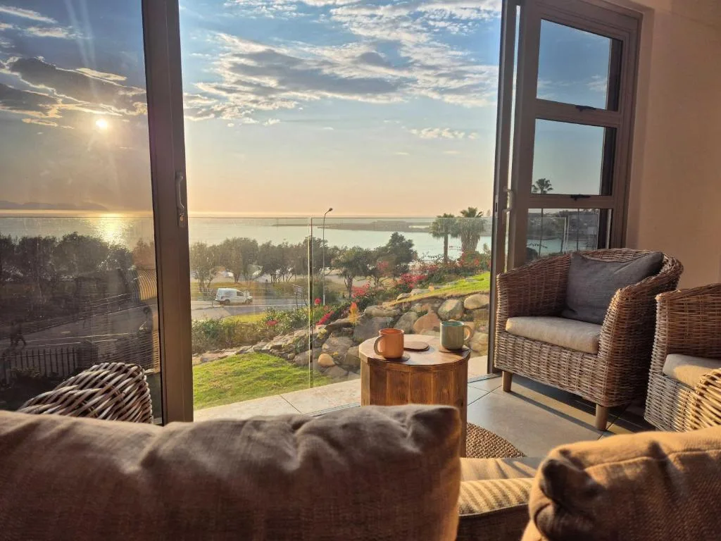 Scenic lagoon sunset view through open glass doors from comfortable seating area