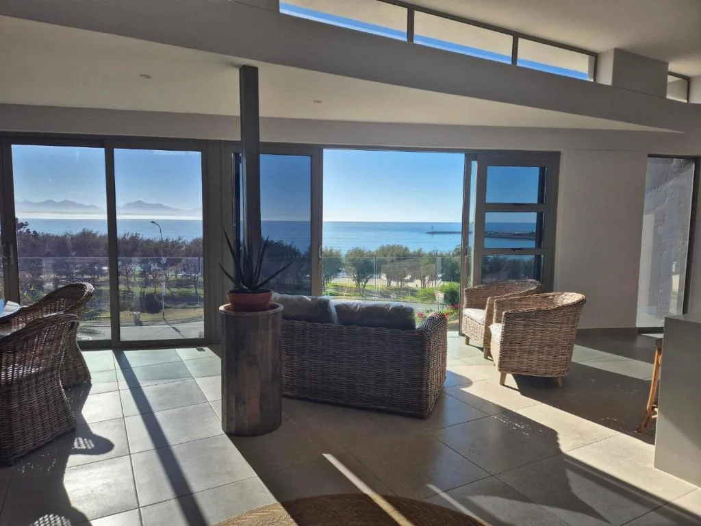 Panoramic ocean and mountain vista through expansive windows from interior seating