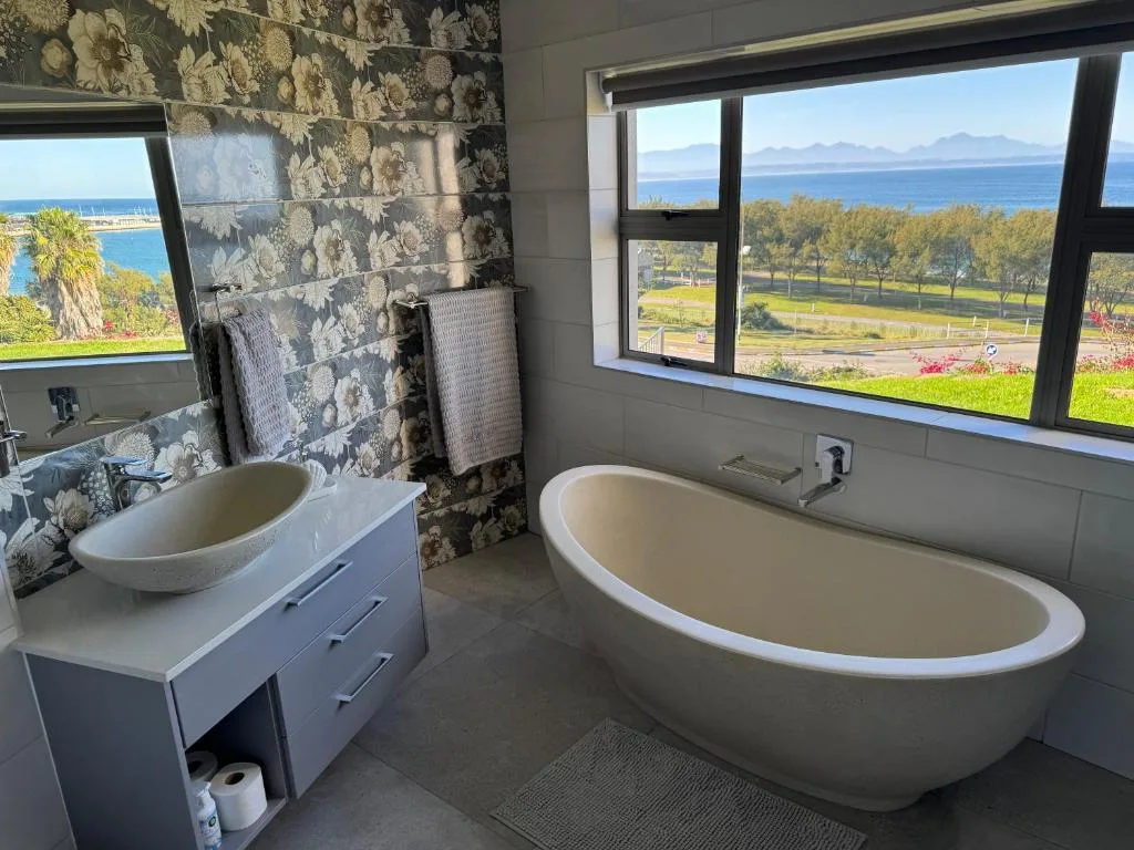 Luxurious bathroom with freestanding tub and ocean views through windows
