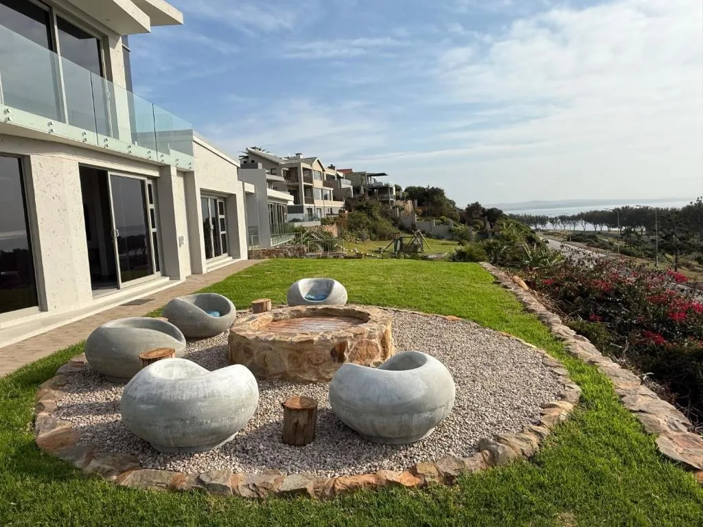 Modern outdoor seating area with spherical concrete seats around firepit