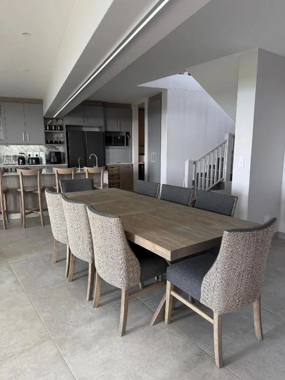 Modern dining table with upholstered chairs in open-plan interior