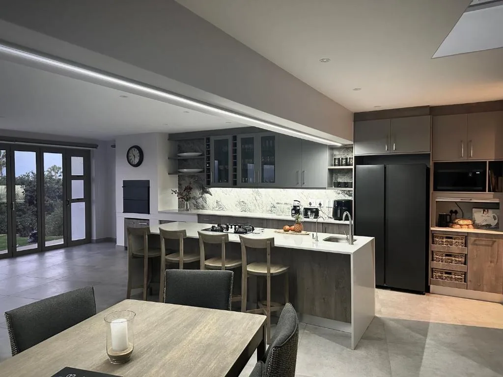 Modern kitchen with island seating, marble countertops, and black appliances