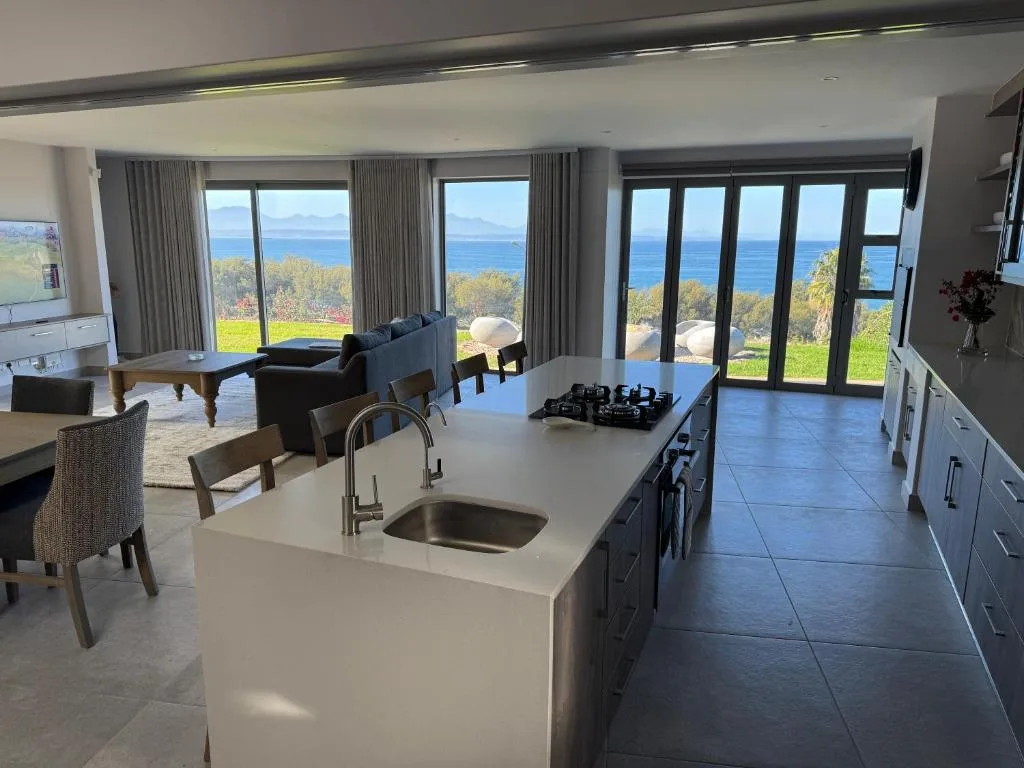 Modern kitchen with island counter overlooking ocean and garden views