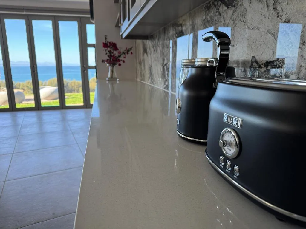 Modern kitchen with black retro toaster and ocean view through large windows