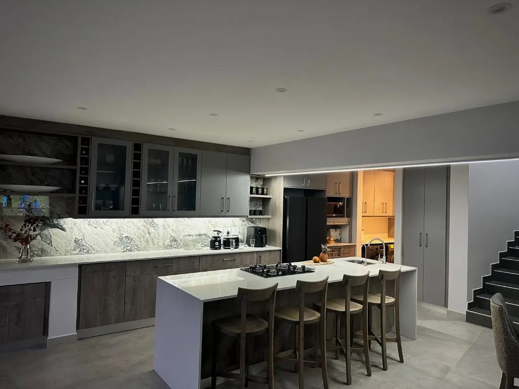 Modern kitchen with marble backsplash, island seating, and stainless steel appliances