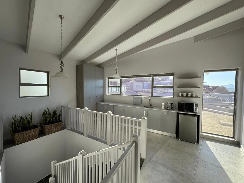 Modern kitchen with grey cabinetry, stainless steel appliances, and coastal views