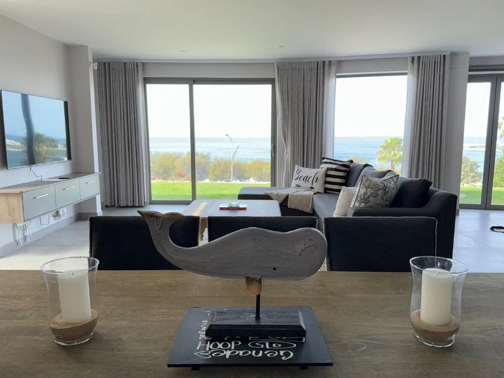 Modern lounge with ocean views through floor-to-ceiling windows and coastal decor