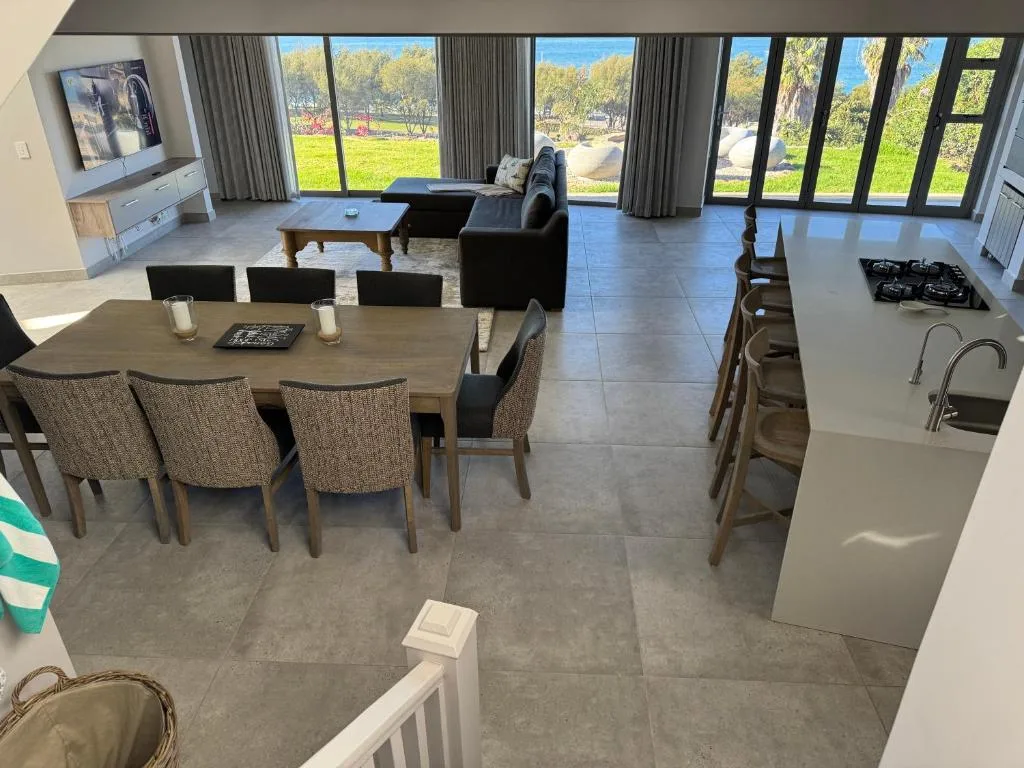 Open-plan living space with dining table, seating, and garden views