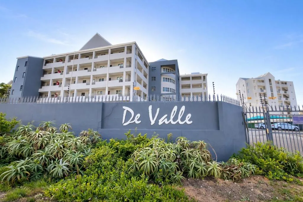 De Valle apartment complex facade with white balconies and signage