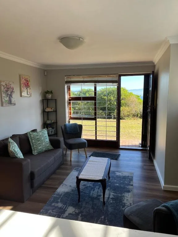 Modern lounge with gray sofa, ocean view through glass doors