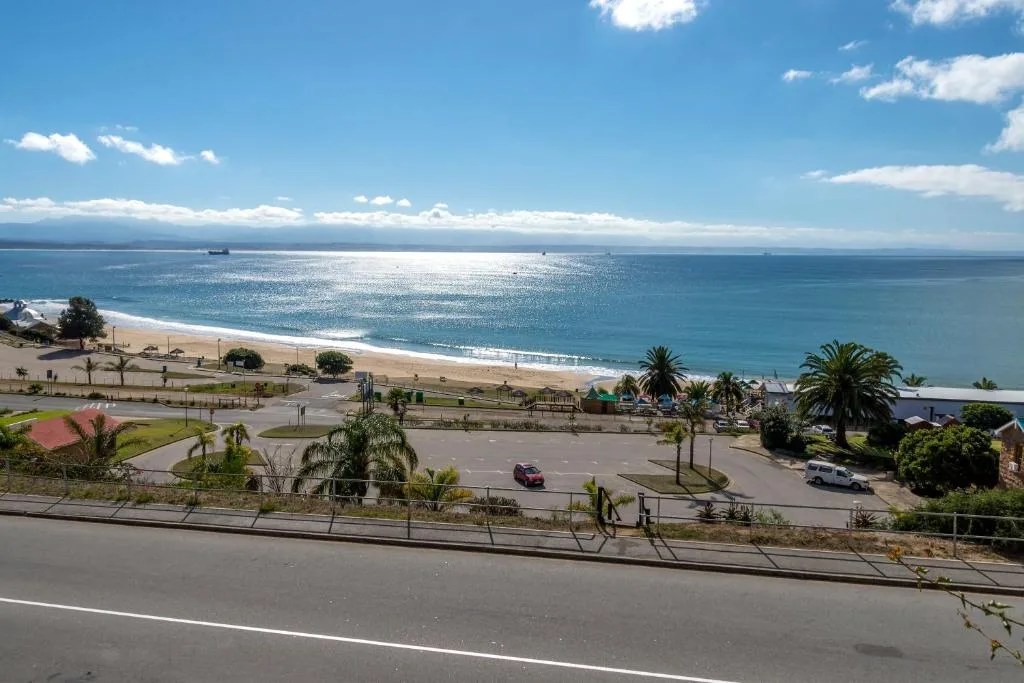 Expansive ocean and beach vista with blue sky and coastal town below