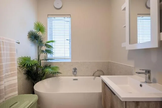 Modern bathroom with white freestanding tub and dual vanity sinks